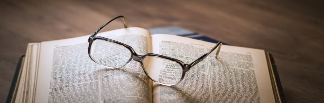 Glasses magnifying text in a book