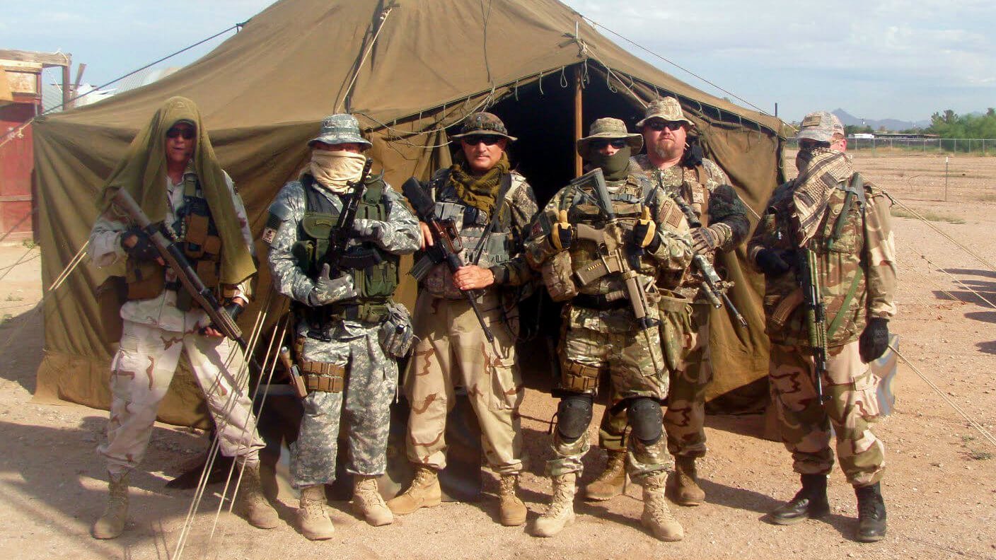 Members of an Arizona militia pose with weapons for the camera.