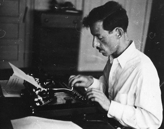 Harold Courlander writing on typewriter.