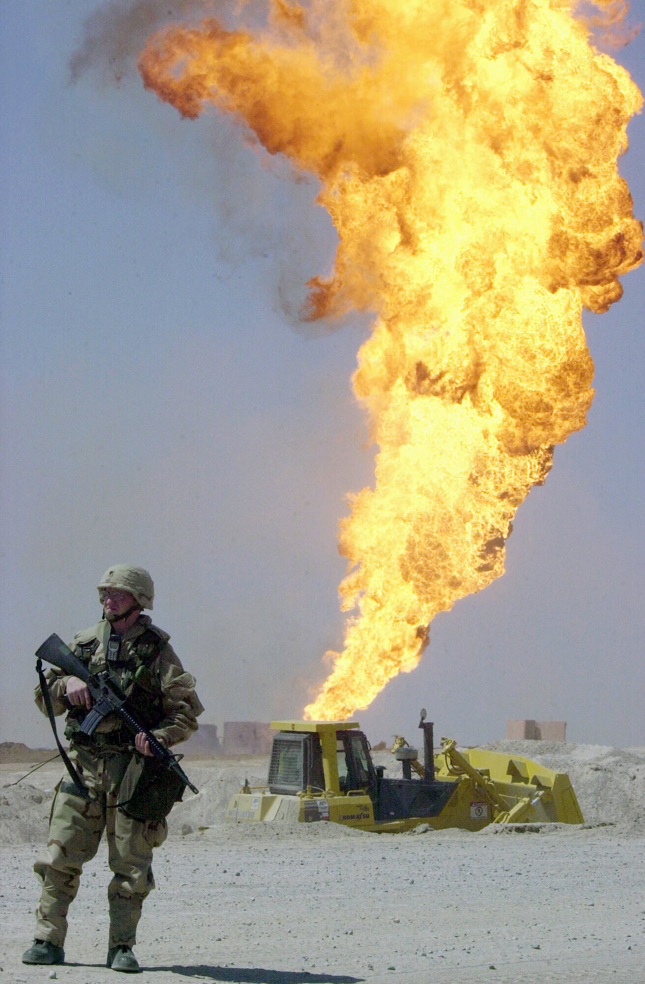 Soldier near burning oil well in Rumaylah oil field